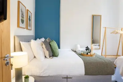 a bedroom with a white bed with pillows at Coningsby House - Air Host & Stay - 6BR, Sleeps 14 in Liverpool