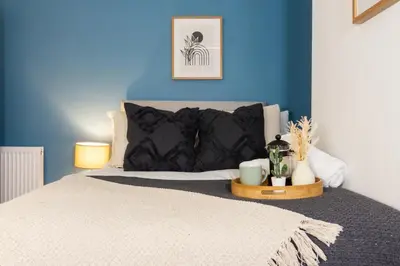 a bedroom with a bed with a blue wall at Coningsby House - Air Host & Stay - 6BR, Sleeps 14 in Liverpool