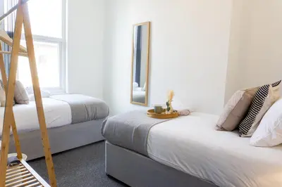 a bedroom with two beds and a mirror at Coningsby House - Air Host & Stay - 6BR, Sleeps 14 in Liverpool