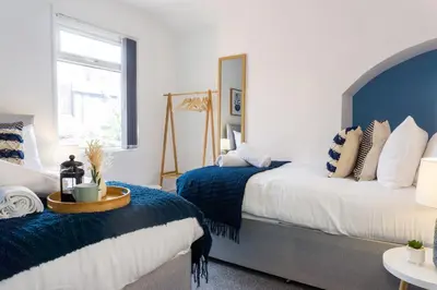 a bedroom with two beds with blue and white at Coningsby House - Air Host & Stay - 6BR, Sleeps 14 in Liverpool
