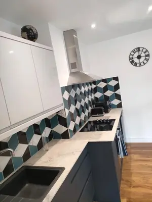 a kitchen with black and white tiles on the wall at Lovely refurbished apartments, Morecambe Promenade in Morecambe