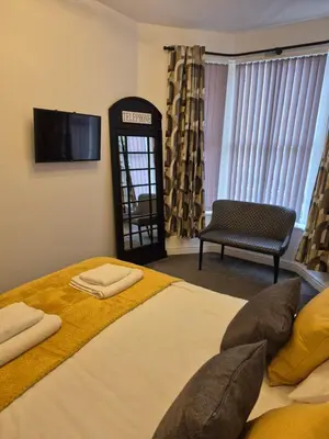 a bedroom with a bed and a phone booth at Lovely refurbished apartments, Morecambe Promenade in Morecambe