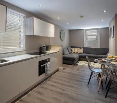 a kitchen and living room with a couch and a table at Coral Boutique Apartment 2 in Blackpool