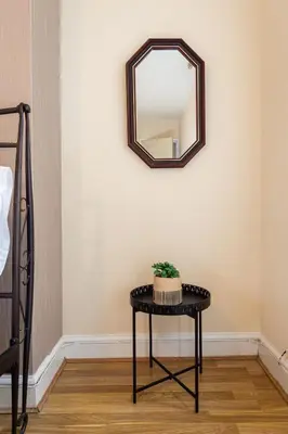 a mirror on a wall above a table with a plant on it at The Chestnut - Liverpool City - L7 in Liverpool
