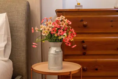 a vase of flowers sitting on a table next to a bed at The Chestnut - Liverpool City - L7 in Liverpool