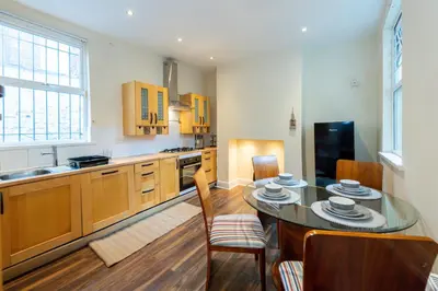 a kitchen with a table and chairs and a kitchen with a sink at The Chestnut - Liverpool City - L7 in Liverpool