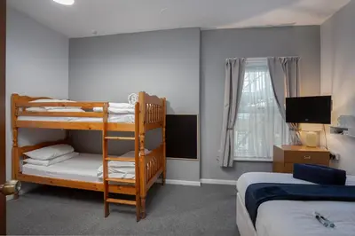 a bedroom with two bunk beds and a television at Royal Oakwell Hotel in Blackpool