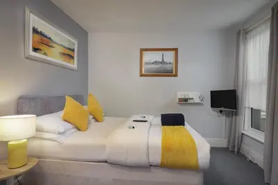 a bedroom with a large white bed with yellow pillows at Royal Oakwell Hotel in Blackpool