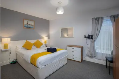 a bedroom with a large bed and a window at Royal Oakwell Hotel in Blackpool