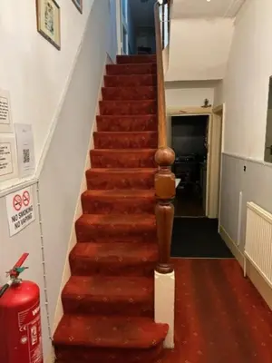 a staircase in a house with a red carpet at Argyll guest house in Blackpool