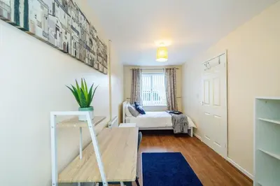 a small room with a bed and a stair case at *Superb Location* Large 4 Bedroom City Centre Home in Liverpool