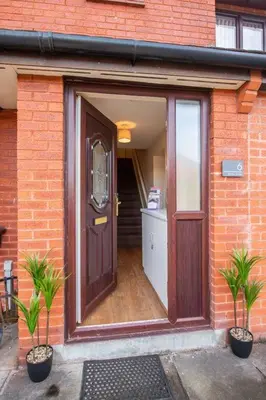a door to a brick building with two potted plants at *Superb Location* Large 4 Bedroom City Centre Home in Liverpool
