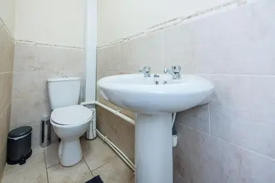 a bathroom with a white sink and a toilet at *Superb Location* Large 4 Bedroom City Centre Home in Liverpool