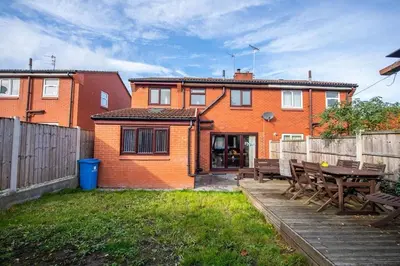 a house with a wooden fence and a wooden table at *Superb Location* Large 4 Bedroom City Centre Home in Liverpool