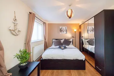 a bedroom with a large bed and a mirror at *Superb Location* Large 4 Bedroom City Centre Home in Liverpool