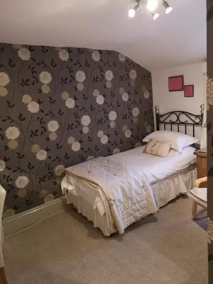 a bedroom with a bed with a black and white wallpaper at East Mount House in Barrow in Furness