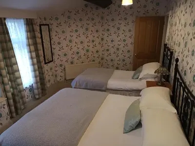 a bedroom with two beds and a window at East Mount House in Barrow in Furness