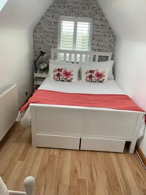 a bedroom with a large white bed with red sheets at Brenda & Petes in Birkenhead