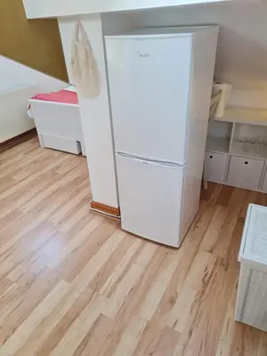 a white refrigerator in a room with a wooden floor at Brenda & Petes in Birkenhead