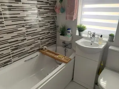 a bathroom with a white tub and a sink at Brenda & Petes in Birkenhead