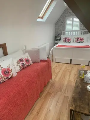 a bedroom with a bed with red sheets and a window at Brenda & Petes in Birkenhead
