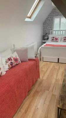 a bedroom with a bed with a red bedspread at Brenda & Petes in Birkenhead