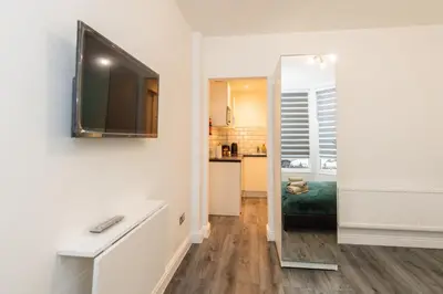 a living room with a television and a mirror at Five Seasons Liverpool City - Modern Studios near Anfield in Liverpool