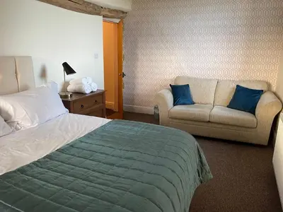 a hotel room with a bed and a couch at Greenbank Farm House in Cartmel