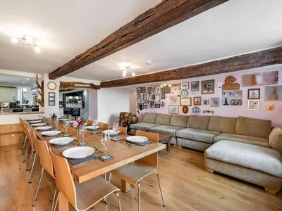 a dining room with a long table and a couch at Greenbank Farm House in Cartmel