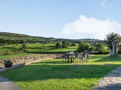 a table and chairs sitting on a grass field at Greenbank Farm House in Cartmel