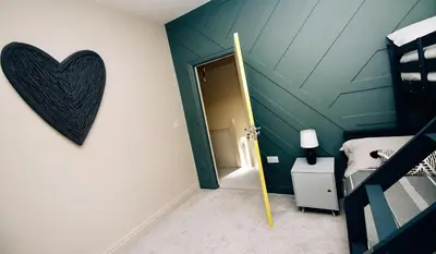 a bedroom with a heart hanging on the wall at XxHot TubxX 4Bed semi, sleeps 8, 2 bathrooms in Blackpool