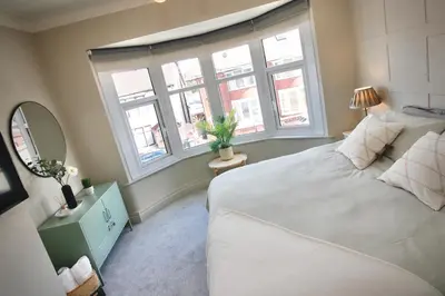 a bedroom with a large white bed and windows at XxHot TubxX 4Bed semi, sleeps 8, 2 bathrooms in Blackpool