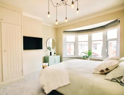 a bedroom with a large white bed and windows at XxHot TubxX 4Bed semi, sleeps 8, 2 bathrooms in Blackpool