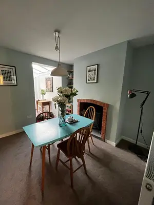 a dining room with a table and chairs and a fireplace at Feather and Twigs Cottage, Croston in Croston