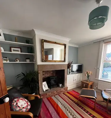 a living room with a fireplace and a mirror at Feather and Twigs Cottage, Croston in Croston