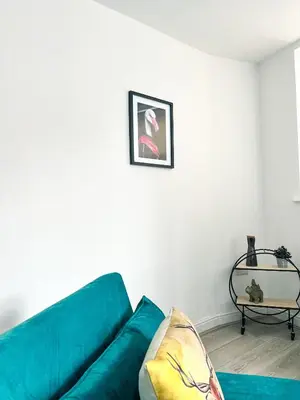 a living room with a blue couch and a table at The County Staycation in Liverpool