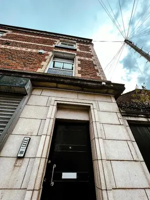a tall brick building with a window and a door at The County Staycation in Liverpool