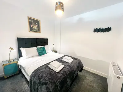 a bedroom with a bed with two towels on it at The County Staycation in Liverpool