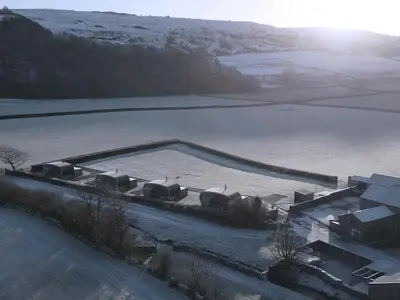 an aerial view of a large frozen lake with snow at Low Longlands in Cartmel