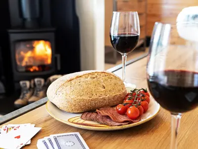 a plate of meat and bread and a glass of wine at Middle Longlands in Cartmel