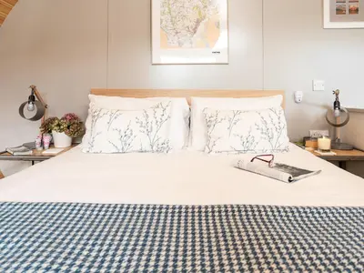 a bed with a pair of glasses and a book on it at Middle Longlands in Cartmel