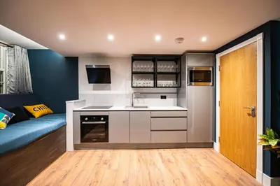 a kitchen with a sink and a couch in a room at The Nest - Luxury 16 person Apt w jacuzzi & parking in Blackpool