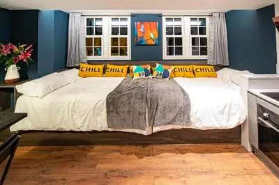 a bedroom with a large white bed with yellow pillows at The Nest - Luxury 16 person Apt w jacuzzi & parking in Blackpool