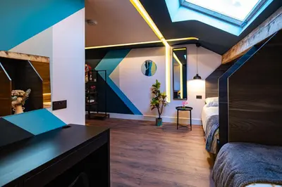 a loft bedroom with a bed and a skylight at The Nest - Luxury 16 person Apt w jacuzzi & parking in Blackpool