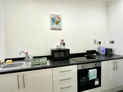 a kitchen with a sink and a microwave at York Street Apartments by Blackpool Service Apartments in Blackpool
