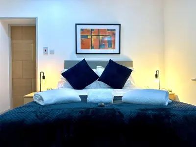 a bedroom with a bed with blue pillows at York Street Apartments by Blackpool Service Apartments in Blackpool