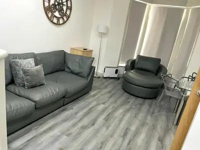 a living room with a couch and a chair at York Street Apartments by Blackpool Service Apartments in Blackpool