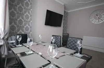 a dining room with a table with wine glasses at Pleasure Beach View in Blackpool