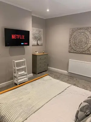 a bedroom with a bed and a tv on the wall at Pleasure Beach View in Blackpool