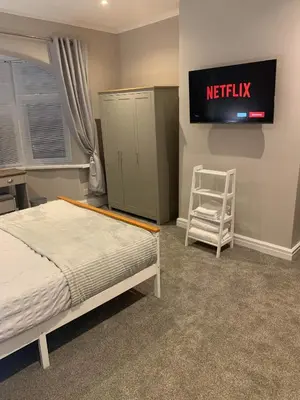 a bedroom with a bed and a tv and a chair at Pleasure Beach View in Blackpool